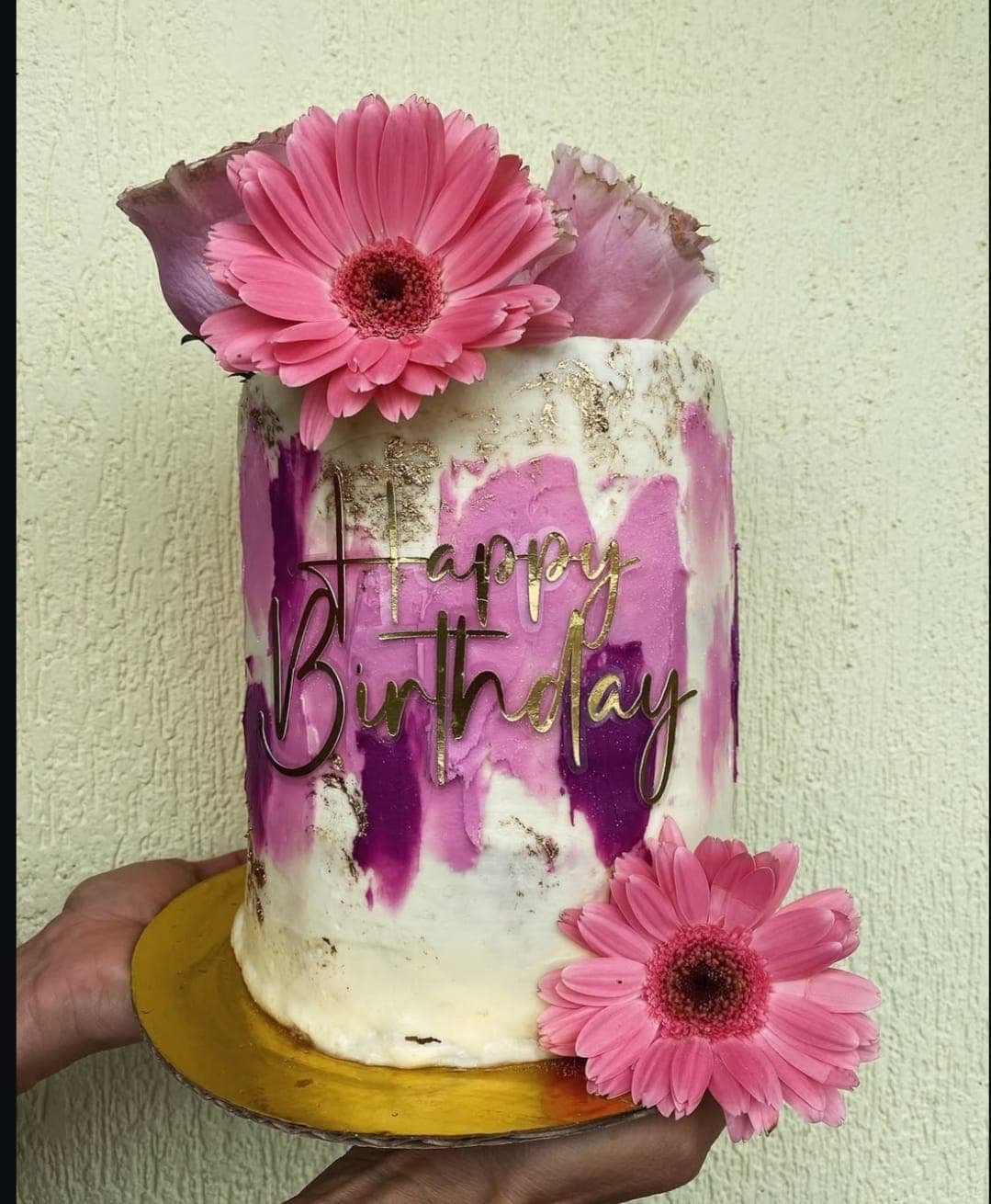 Torta de cumpleaños con flores de gerbera y detalles dorados